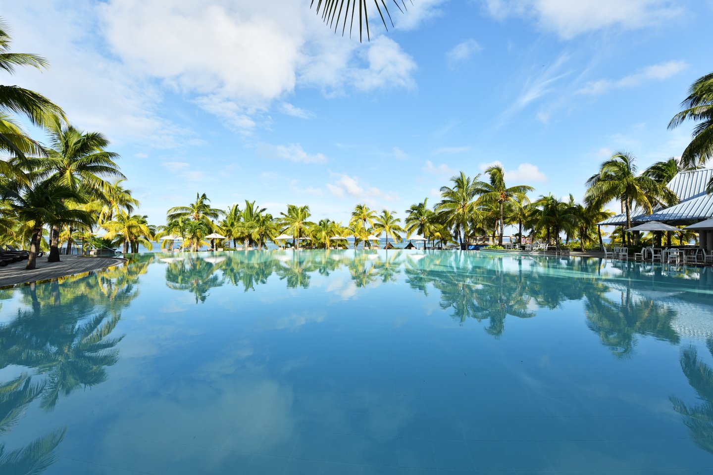 Poolanlage mit Palmen im Victoria Beachcomber