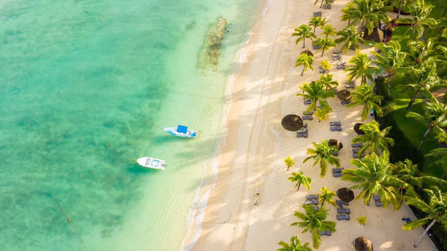 Strand mit Palmen und Booten am Victoria Beachcomber