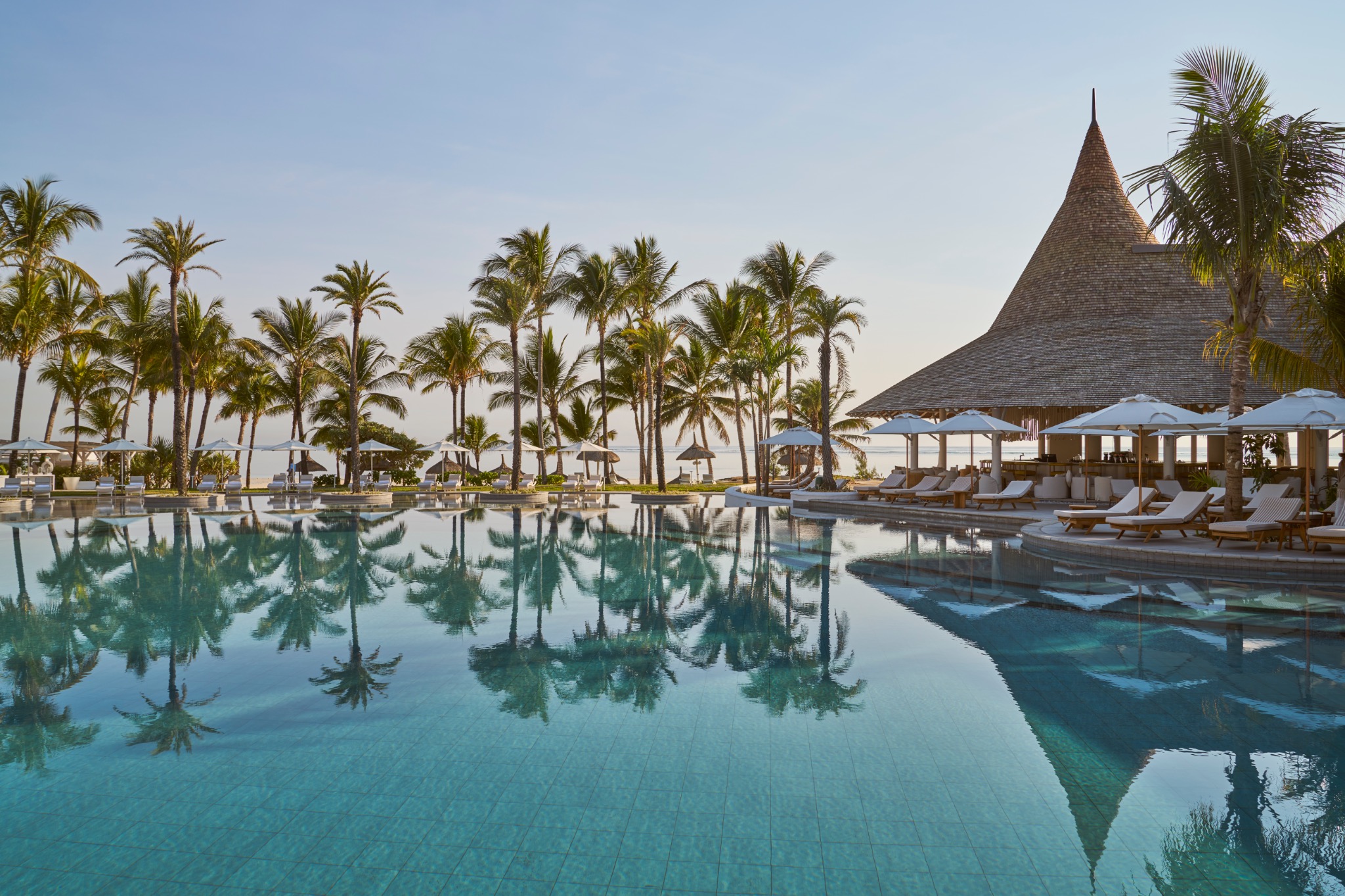 Pool und palmengesäumte Terrasse im LUX* Belle Mare