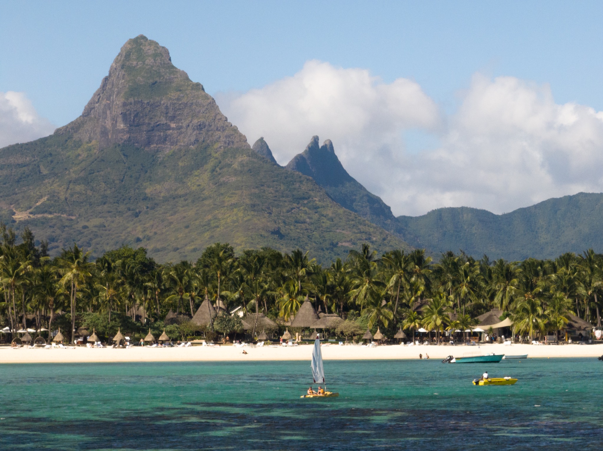 Strand und Wassersport vor La Pirogue mit Bergen im Hintergrund