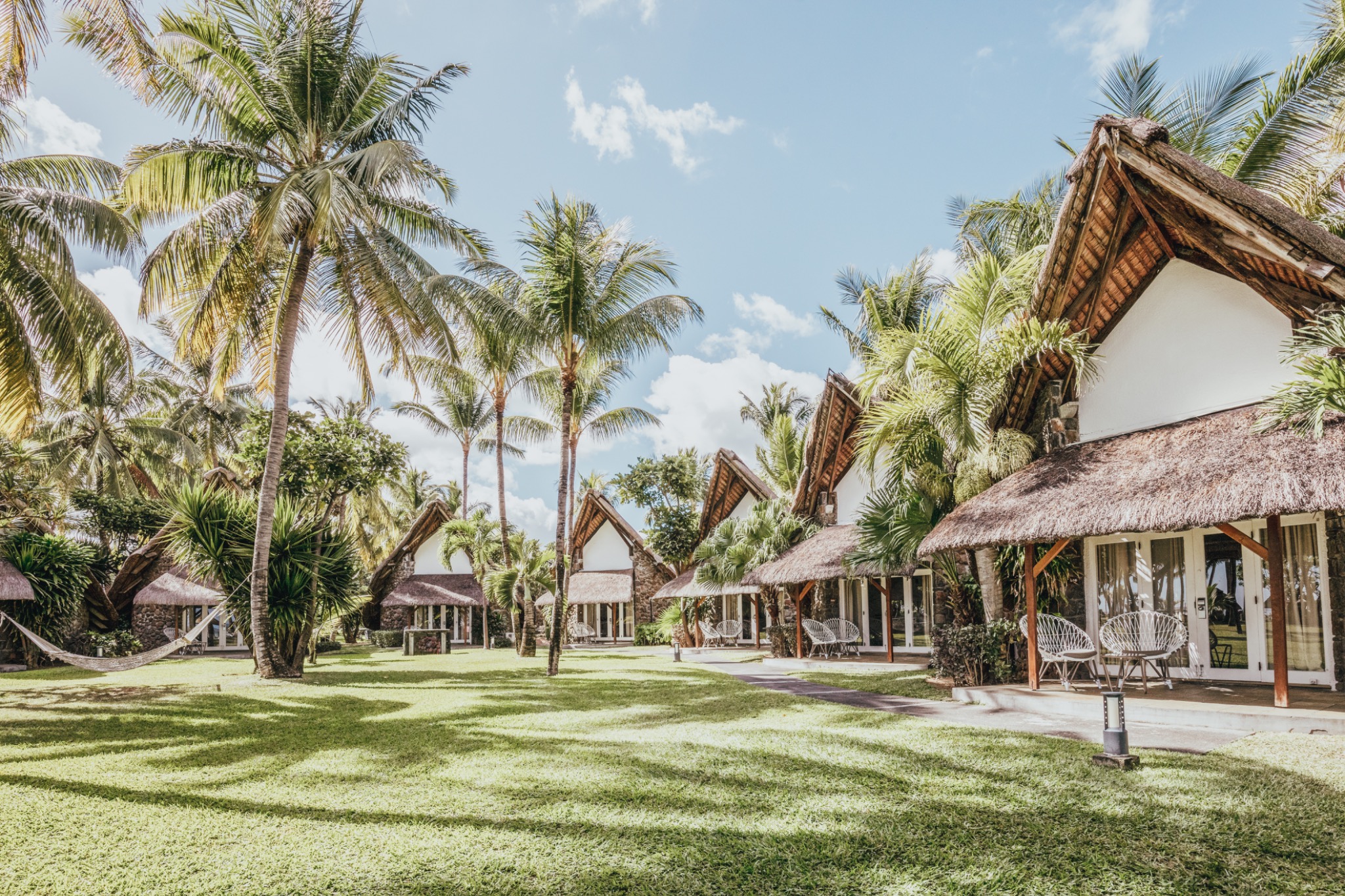 Strohgedeckte Bungalows im Palmengarten des La Pirogue Mauritius